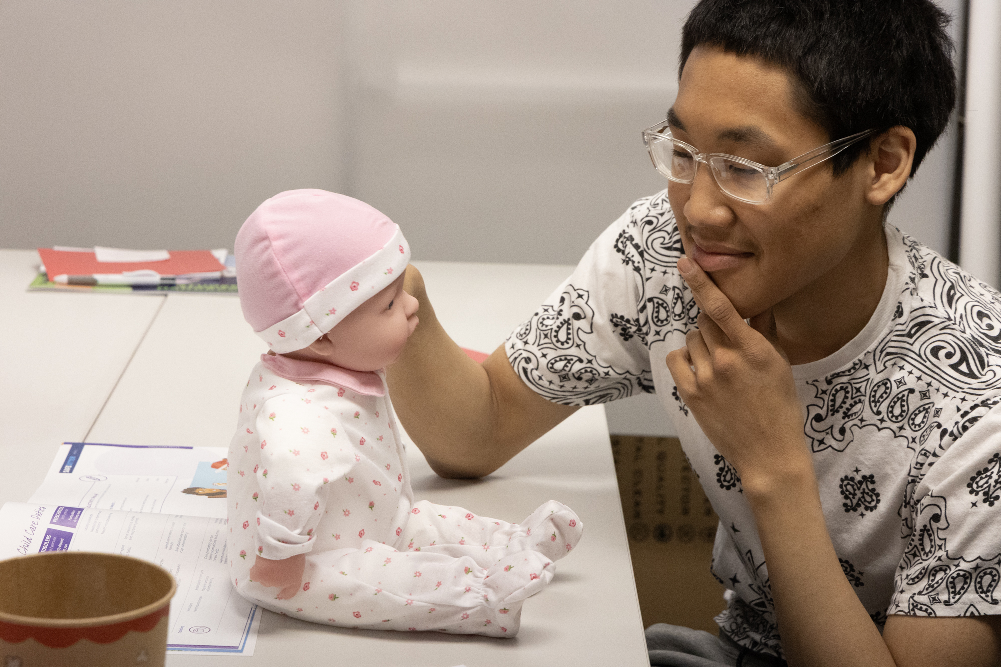 Summer camp student looks at a baby doll