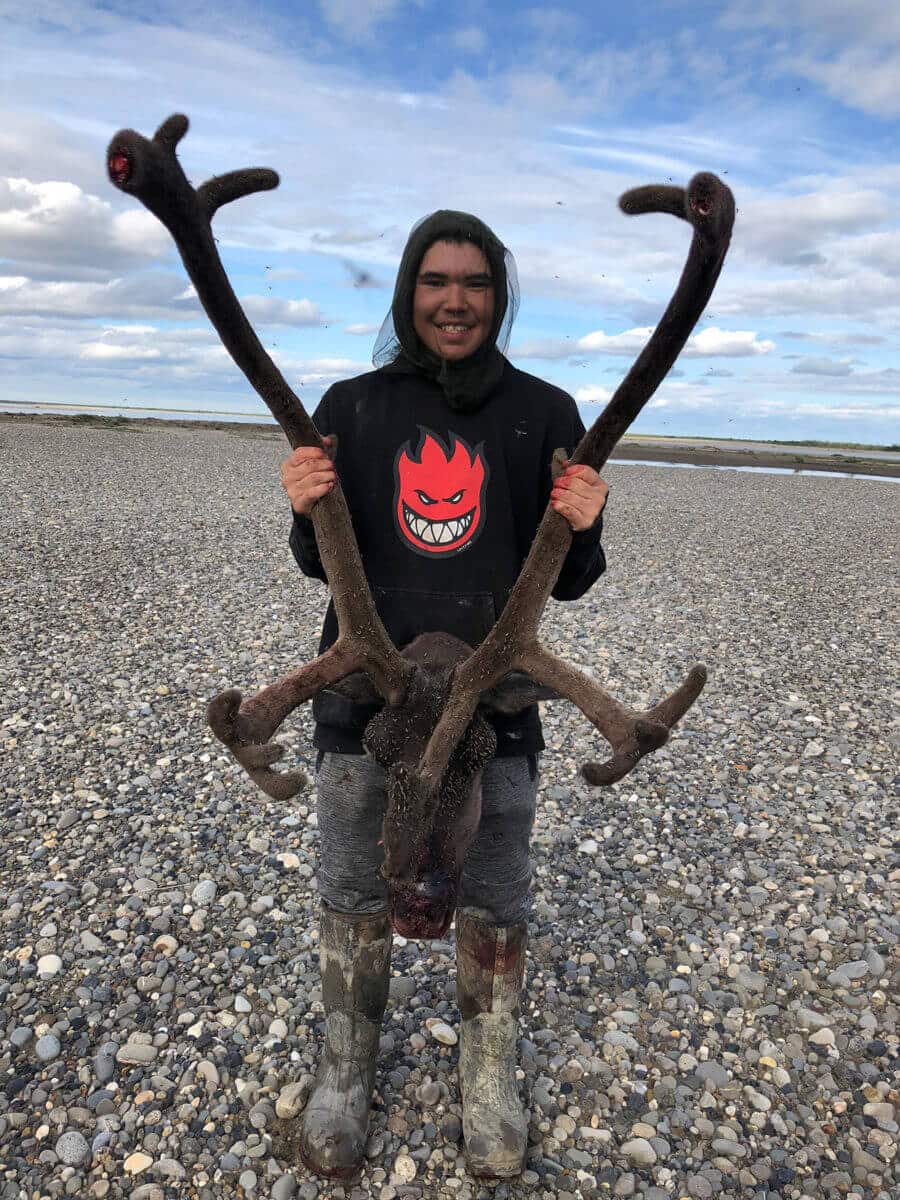 Student posing with caribou antlers.