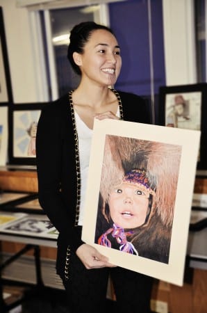 Smiling Jamie holding up a large photograph.